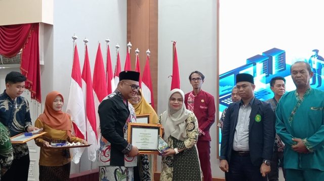 Bupati Kukar Aulia Rahman Basri saat menyerahkan hadian penganugerahan literasi Kukar. (Lingkar Kaltim/M. As'ari)