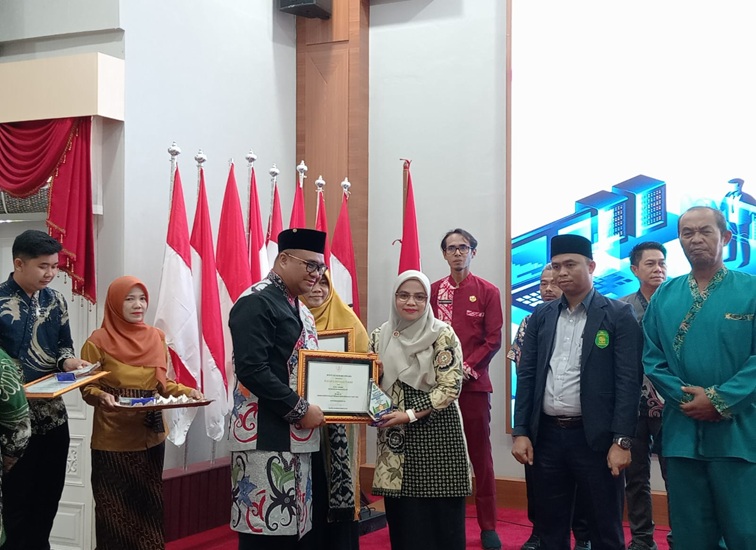 Bupati Kukar Aulia Rahman Basri saat menyerahkan hadian penganugerahan literasi Kukar. (Lingkar Kaltim/M. As'ari)