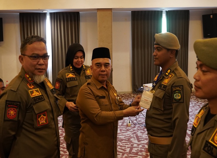 Kepala Satpol PP Kukar Arfan Boma Pratama dengan Asisten I Setdakab Kukar Ahmad Taufik Hidayat saat menyematkan tanda peserta pelatihan. (Lingkarkaltim/M. As'ari)
