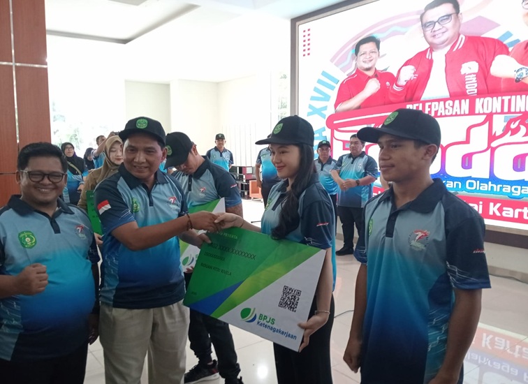 Asisten II Ahyani Fadianur Diani saat menyerahkan BPJS Ketenagakerjaan untuk perwakilan atlet Kukar ke Popda Kaltim di PPU. (Lingkar Kaltim/M. As'ari)