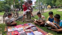 Anak-anak yang sedang membaca di lapak gratis Komunitas Literasi Pixelarasi di Taman Tenggarong. (Lingkar Kaltim/M. As'ari)