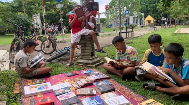 Anak-anak yang sedang membaca di lapak gratis Komunitas Literasi Pixelarasi di Taman Tenggarong. (Lingkar Kaltim/M. As'ari)