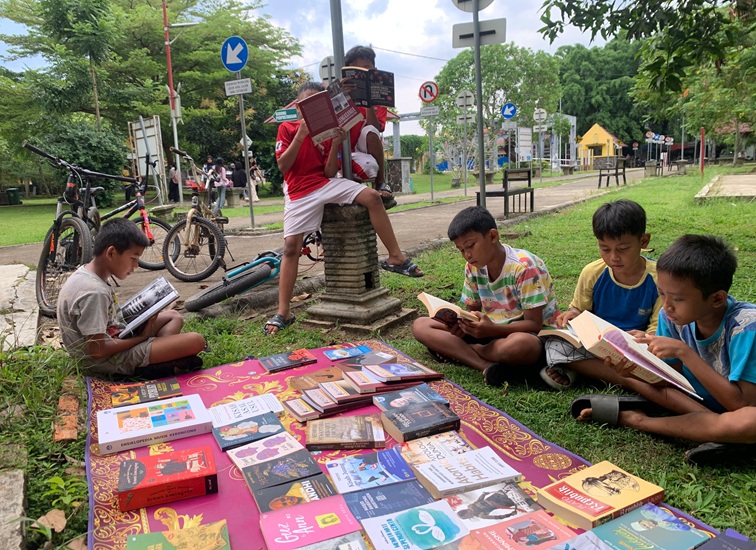 Anak-anak yang sedang membaca di lapak gratis Komunitas Literasi Pixelarasi di Taman Tenggarong. (Lingkar Kaltim/M. As'ari)