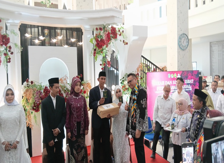 Bupati Kukar dr. Aulia Rahman Basri bersama salah satu pasangan nikah massal. (Lingkar Kaltim/M. As'ari)