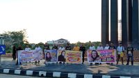 Warga Tenggarong yang membentangkan spanduk menyambut kepulangan mantan Bupati Kukar, Rita Widyasari. (Lingkar Kaltim/M. As'ari)