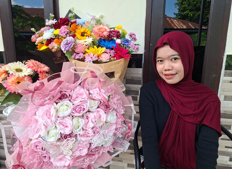 Anis beserta bucket bunga yang dijualnya, Selasa (23/6/26). (Dilla/lingkarkaltim)