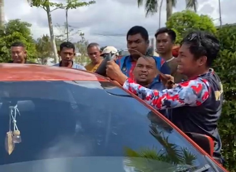 Anggota Damkar mencoba membuka paksa pintu mobil memakai besi pengait, Jumat (19/6/26). (Doc. Disdamkarmatan Kukar)