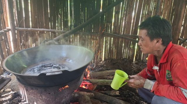 Kuyun sedang memasak air aren di dapur kayu sederhana miliknya, Jalan Triyu 2 dekat kuburan seradak, Tenggarong, Sabtu (20/6/26). (Dilla/lingkarkaltim)