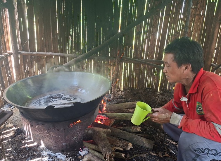 Kuyun sedang memasak air aren di dapur kayu sederhana miliknya, Jalan Triyu 2 dekat kuburan seradak, Tenggarong, Sabtu (20/6/26). (Dilla/lingkarkaltim)