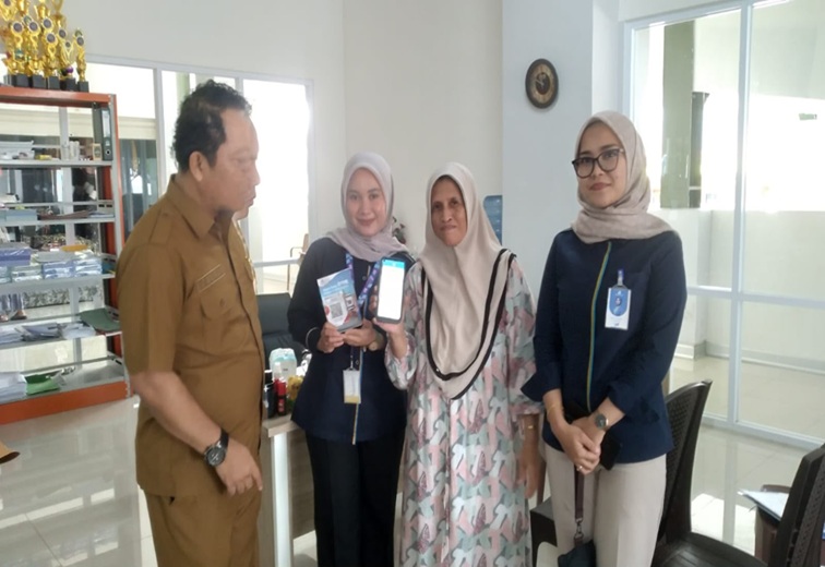Plt. Kepala Disperindag Kukar, Sayid Fathullah bersama pedagang saat menunjukkan sistem pembayaran retribusi lapak secara non-tunai (Kiki/Lingkarkaltim)
