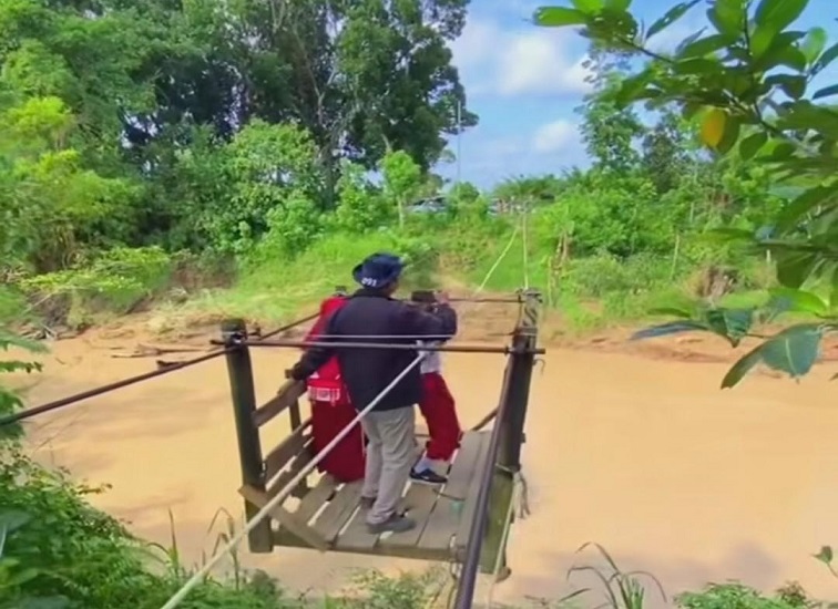 Tangkapan layar video viral yang memperlihatkan perjuangan anak-anak SD di RT 9 Dusun Damai, Desa Santan Ulu, saat menyeberangi sungai menggunakan kereta gantung rakitan. (Dok. Facebook Arian)