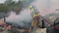 Personil Damkar saat melakukan pendinginan mes bangsalan, Tenggarong Seberang, Desa Karang Tunggal, Jumat (17/7/26). (Doc. Damkarmatan Kukar)