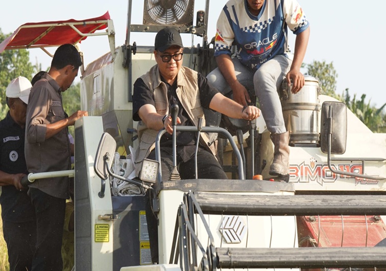Bupati Kukar dr. Aulia Rahman Basri mengendarai Combine harvester saat panen di Desa Sungai Payang. (dok. Kukar.kab.go.id)