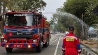 Kadisdamkarmatan Kukar, Fida bersama anggota menyiram tanaman sepanjang turapan timbau menggunakan mobil watter supply, Tenggarong (1/9/26). (Doc. Damkarmatan Kukar)