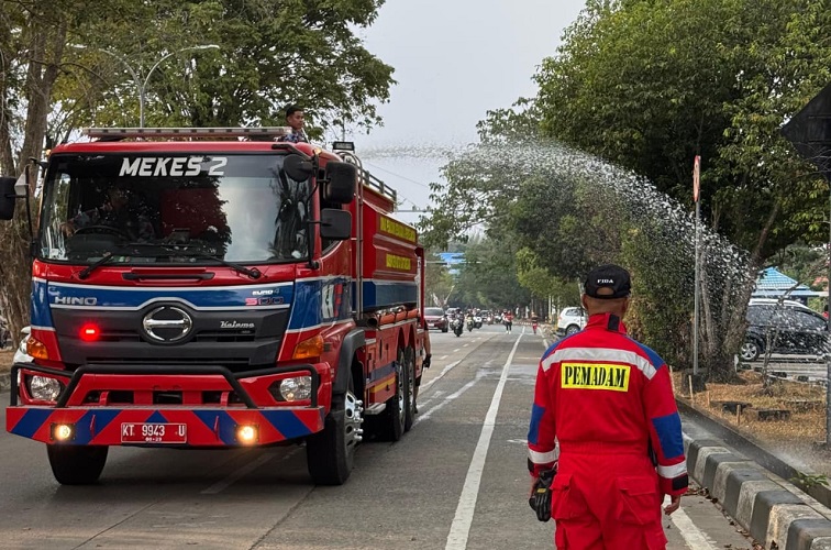 Kadisdamkarmatan Kukar, Fida bersama anggota menyiram tanaman sepanjang turapan timbau menggunakan mobil watter supply, Tenggarong (1/9/26). (Doc. Damkarmatan Kukar)