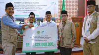 Dirjen Bimas Islam Kemenag Abu Rokhmad menyerahkan bantuan senilai Rp11,6 miliar kepada Kanwil Kemenag Aceh. (Dok. kemenag.go.id)