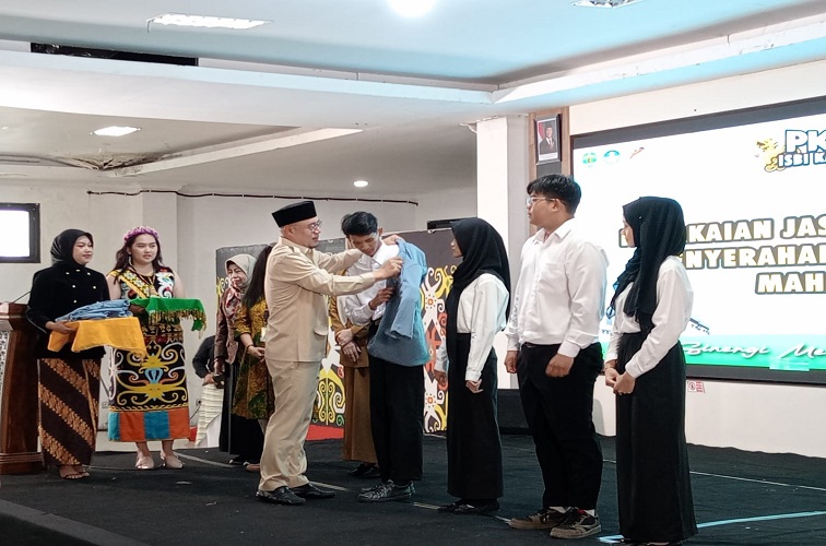 Pemasangan almamater secara simbolis ke perwakilan mahasiswa baru ISBI Kaltim oleh Kepala Disdikbud Kukar Heriansyah. (M. As'ari/Lingkar Kaltim)