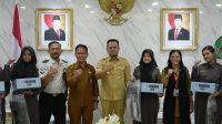 Penyerahan secara simbolis paket perlengkapan seragam sekolah gratis, Selasa (1/9/2026).(Dok. Pemprov Kaltim)
