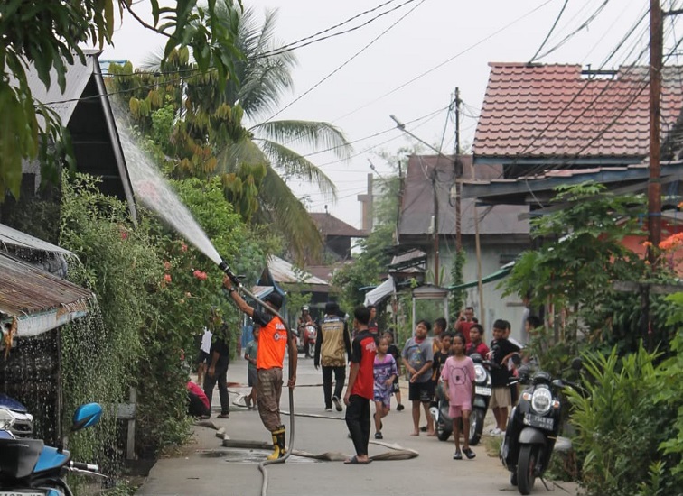 Relawan Balakarcana Tenggarong semprot rumah warga, Sabtu (17/10/2026) (Rizki/Lingkarkaltim)